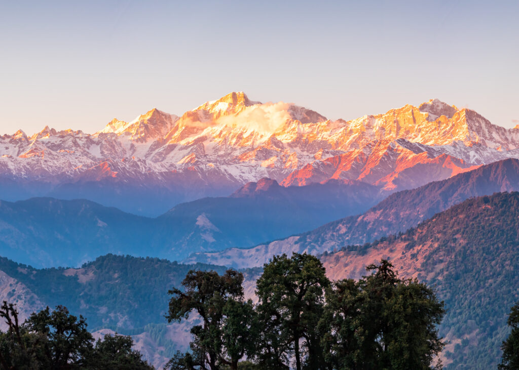 Panoramic view during sunset over snow cladded gangotri group mountain peaks falls in Greater Himalayas mountain range from Chopta, Uttarakhand, India.