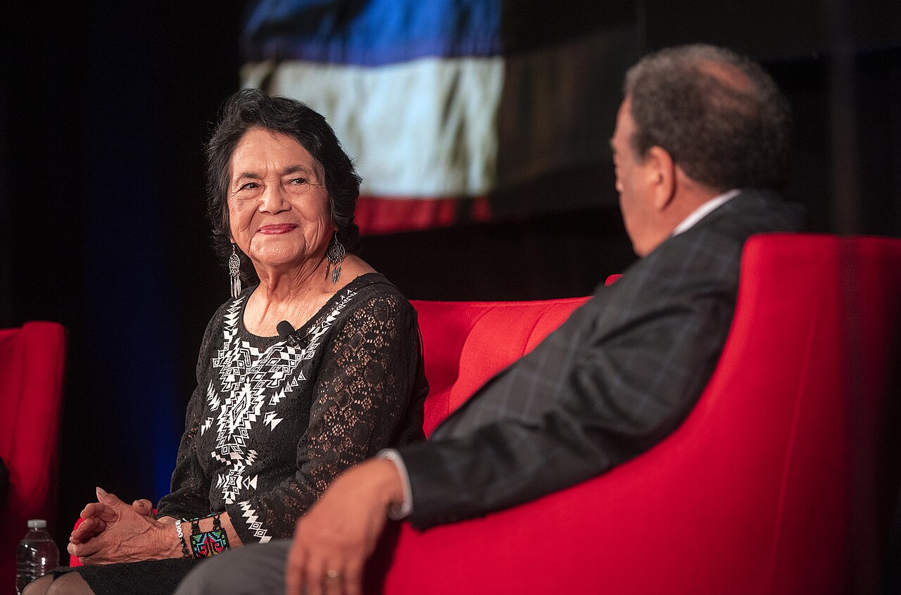 Dolores Huerta smiling as she listens to Andrew Young during a panel at the Summit on Race in America, LBJ Presidential Library, 2019, for a post on how Dolores Huerta organized farmworkers